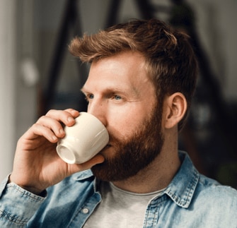 en mann drikker en kopp kaffe